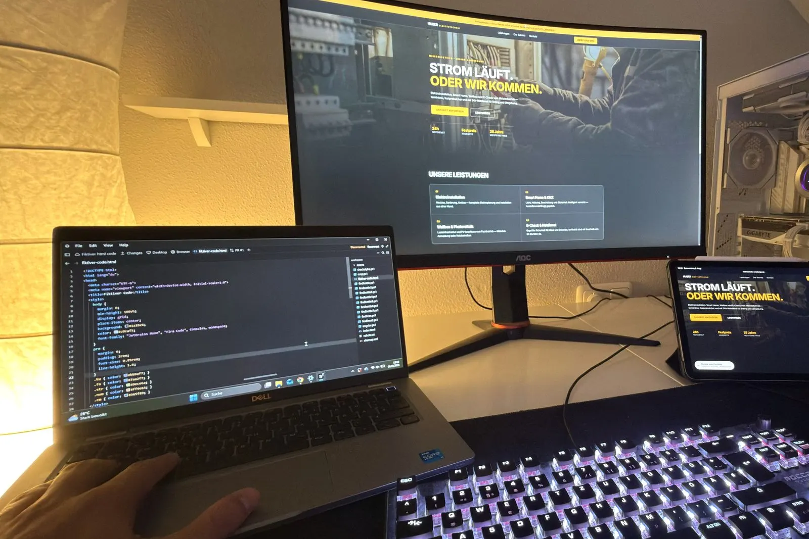 Arbeitsplatz von Andreas Fuchs: ein Entwurf auf dem Monitor, der zugehörige Code auf dem Laptop, dieselbe Seite als Handy-Ansicht auf dem Tablet